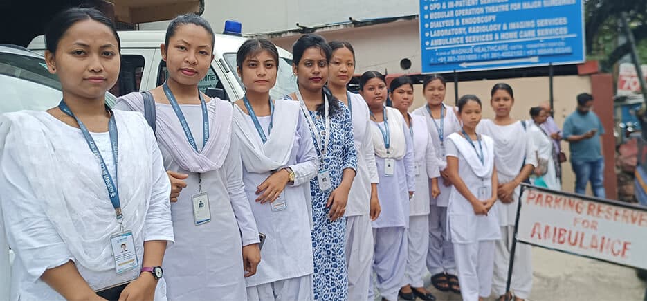 A group of trainees in uniform standing together outside a hospital